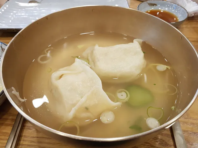 놋그릇에 큼직한 평양만두가 들어있는 맑은 만둣국