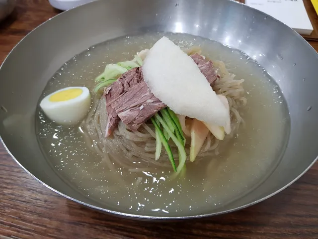 살얼음 육수에 고기 고명과 배, 삶은 달걀이 올라간 물냉면