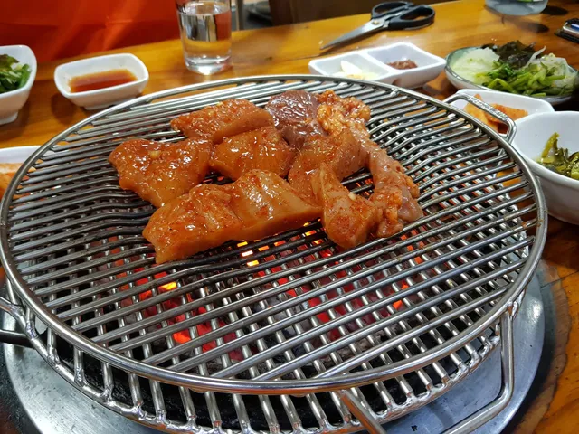 숯불 석쇠 위에 양념된 특양과 대창 등의 양대창구이가 올려져 굽히고 있는 모습