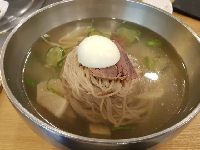 놋그릇에 담긴 맑은 육수의 평양냉면