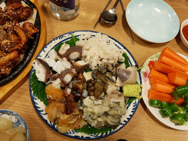문어숙회, 멍게, 해삼, 굴 등 다양한 해산물 모둠과 꼼장어 구이가 차려진 한 상