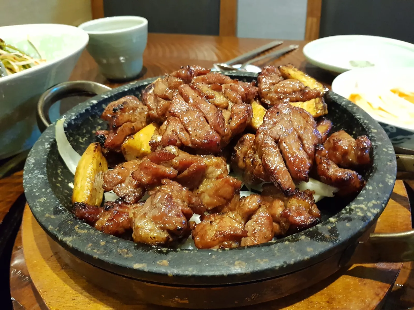 뜨거운 돌판 위에 담겨 나온 양념 돼지갈비 구이