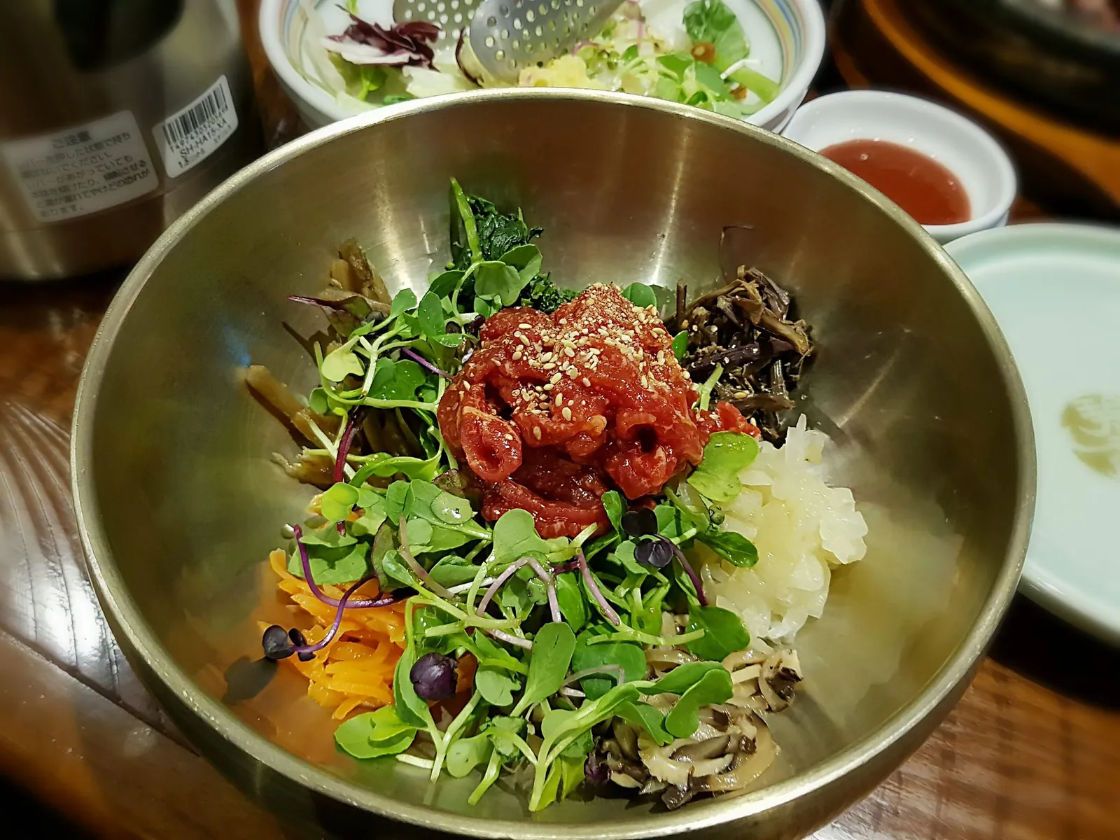 놋그릇에 육회와 신선한 각종 나물, 채소가 정갈하게 담긴 육회비빔밥