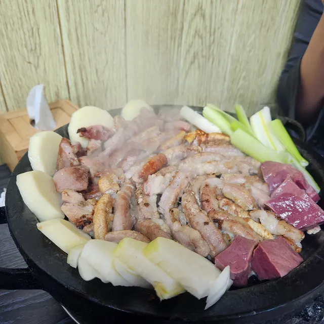 달궈진 불판 위에서 감자, 대파, 염통과 함께 구워지는 소곱창구이