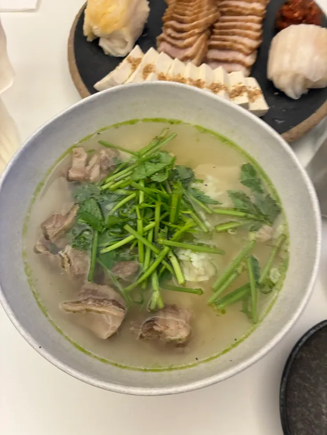 미나리가 올라간 맑은 곰탕과 수육 및 두부김치 한 상