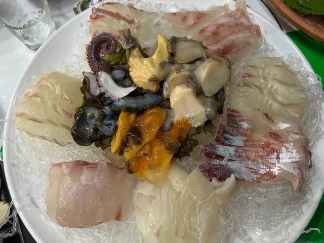 천사채 위에 모둠회와 문어, 해삼, 멍게, 전복 등 해산물이 정갈하게 담겨 있는 모습