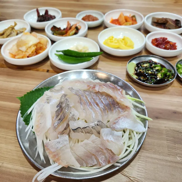 다양한 밑반찬과 함께 스테인리스 접시에 담겨 나온 생선회