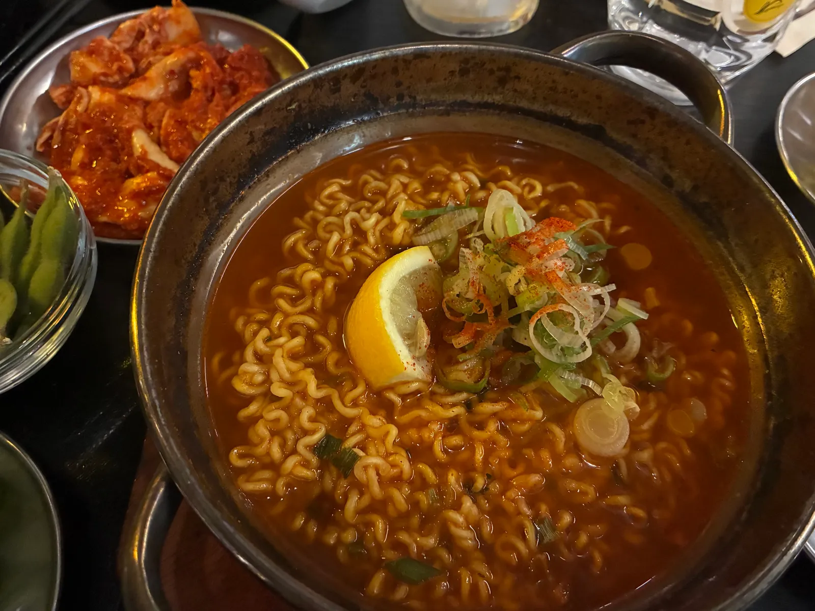 냄비에 담긴 얼큰한 라면과 김치, 완두콩 반찬