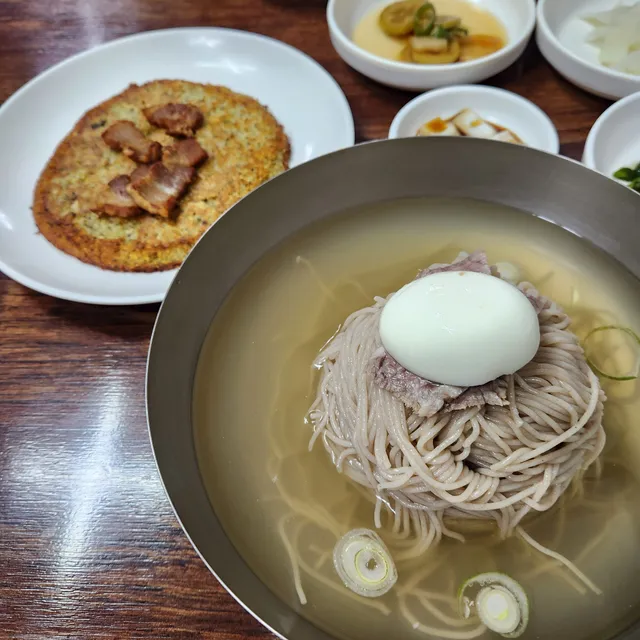 놋그릇에 담긴 평양냉면과 고기가 올려진 녹두전